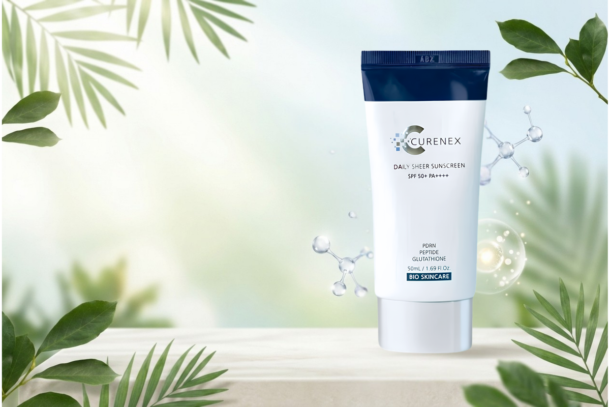 Curenex Daily User Sunscreen SPF 50 sunscreen tube standing on a light surface with decorative green leaves and water droplets around it.