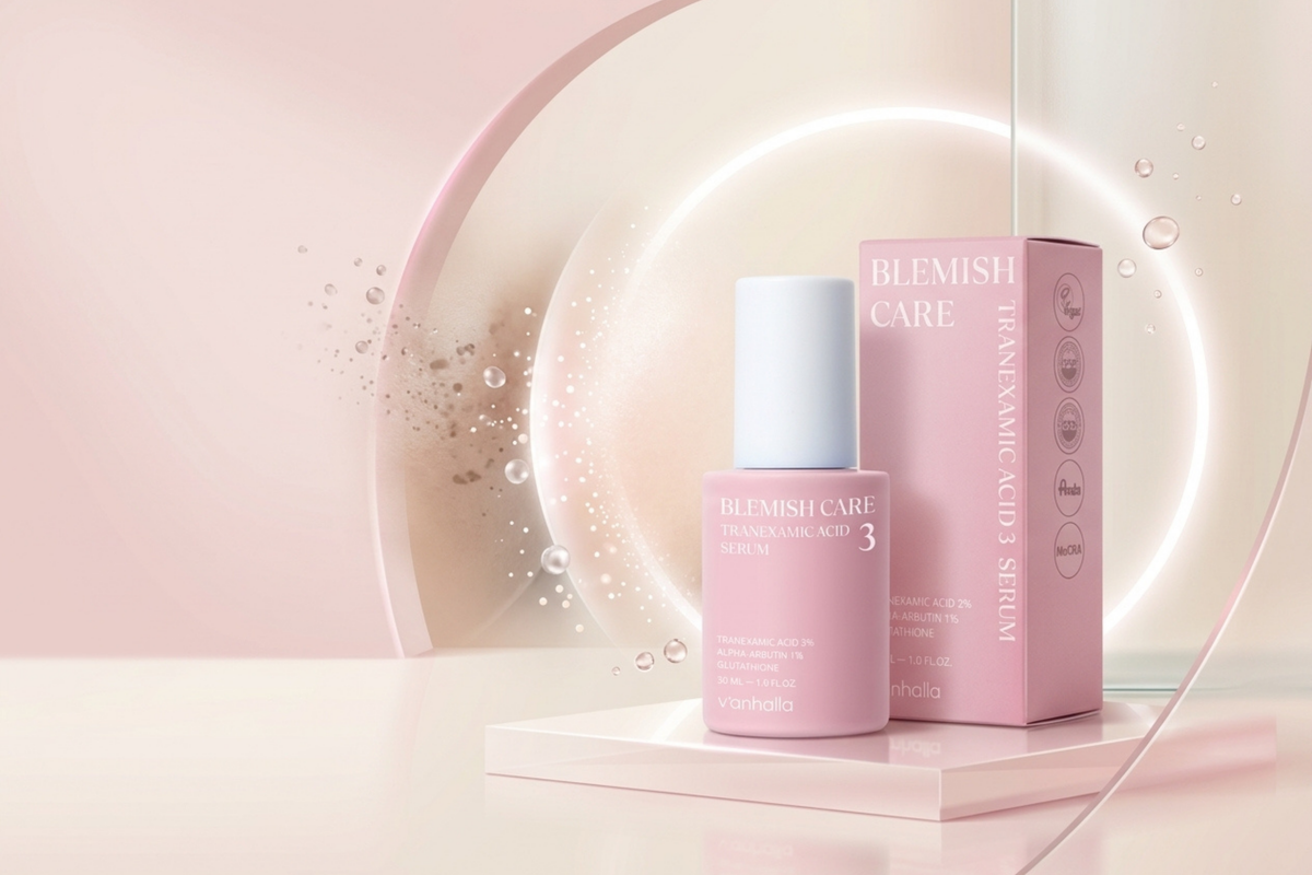 Blemish Care Radiance Glow Serum bottle and matching pink box displayed on a pedestal with a soft pink studio background and glowing circular light.