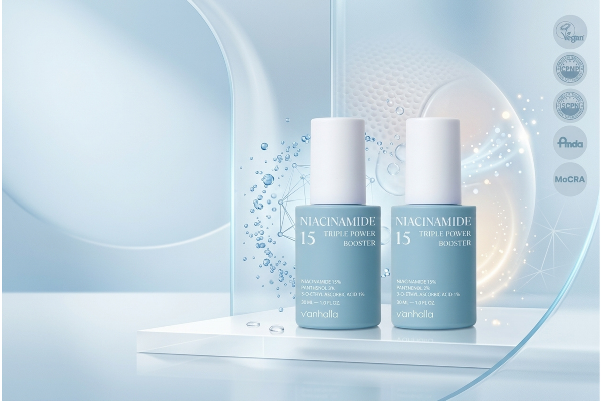 Two cosmetic bottles labeled 'NACAMIDE 15 TRIPLE POWER BOOSTER' by vanhecka, shown on a white platform against a soft blue abstract studio background with water droplets and certification icons on the right.